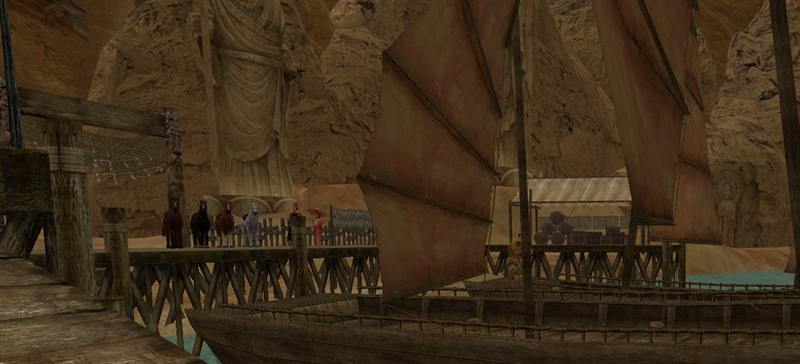 A wooden pier and a junk moored below sandstone cliffs